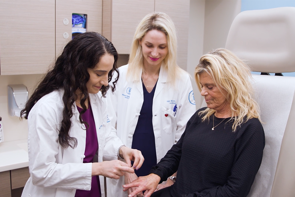 Veronica Rotemberg, MD, PhD, and Alina Markova, MD in clinic with patient. 