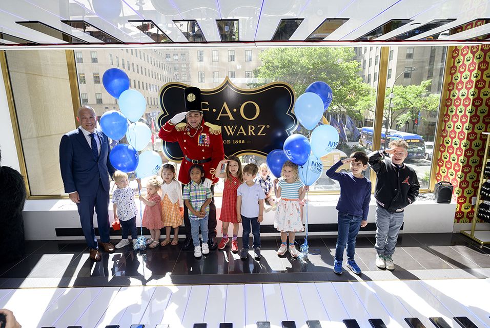 A group of children stands with FAO Schwarz famed toy solider Johnny and MSK’s Dr. Andrew Kung. 